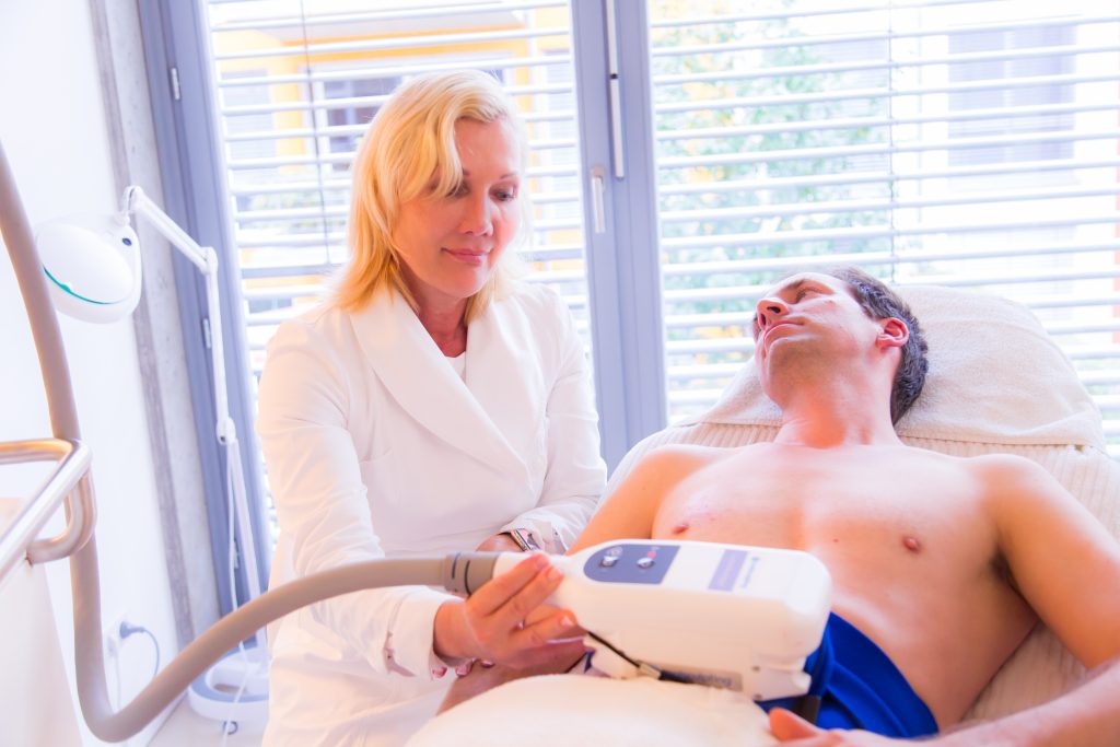 Ärztin behandelt Patienten mit Kältetherapie CoolSculpting am Bauch.